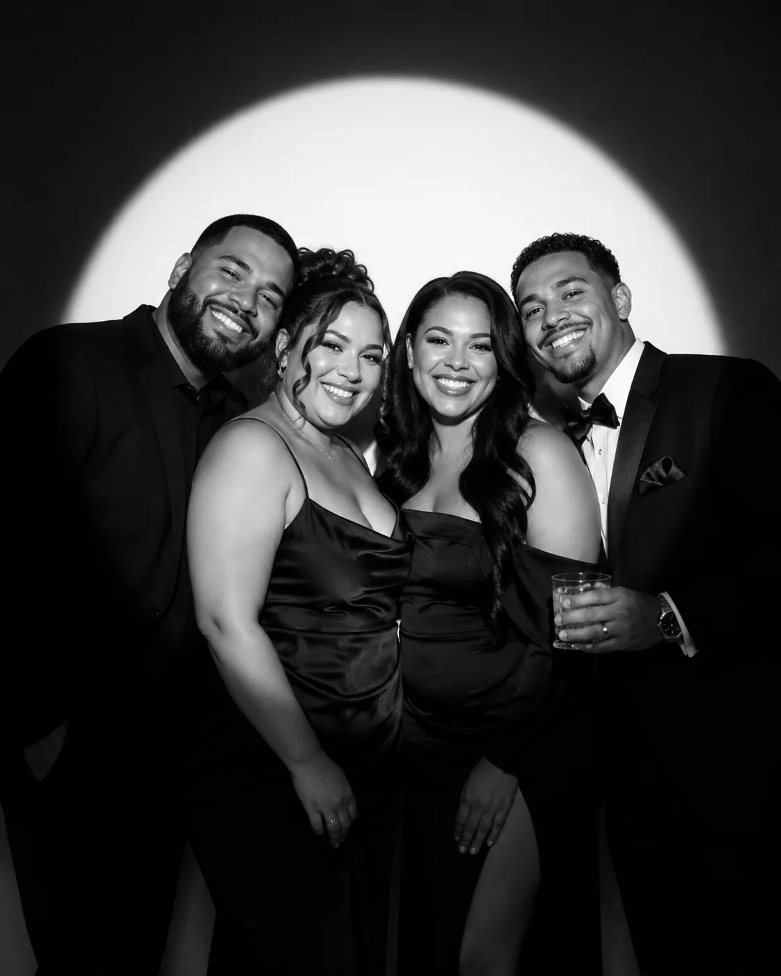 Four guests in black tie photographed in glam black and white
