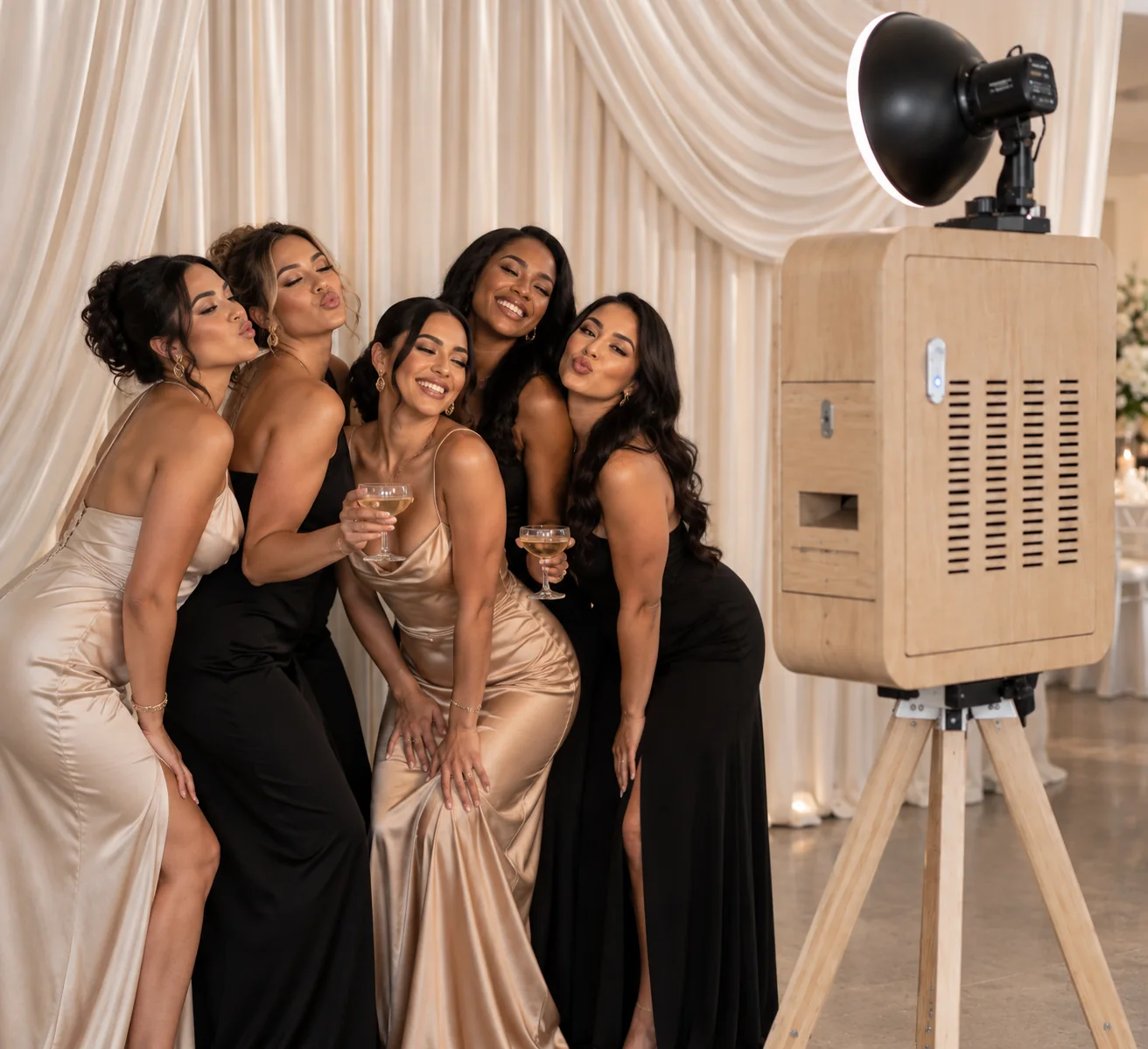 Guests photographed beside the booth against an ivory drape